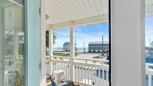 A balcony with a view of the beach and buildings. - 3-Bedroom Gulf Views Retreat - 1 Min to Beach (Mexico Beach)