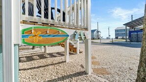 A playground with a wooden slide and a swing set. - 3-Bedroom Gulf Views Retreat - 1 Min to Beach (Mexico Beach)