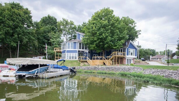 A lakeside house with a dock, a covered boat area, and a wooden staircase leading to a deck. - Lakehouse - Sleeps up to 20 w/ free boat slip.
WINTER REMODEL - PICS COMING SOON (Noblesville)