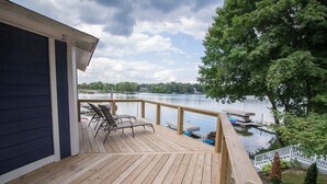 A wooden deck with a view of a lake, a dock with boats, and a flag. - Lakehouse - Sleeps up to 20 w/ free boat slip.
WINTER REMODEL - PICS COMING SOON (Noblesville)