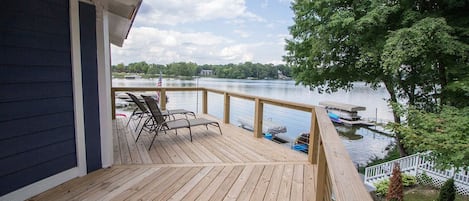 Ein Holzdeck mit Seeblick, eine Anlegestelle mit Booten und eine Flagge.