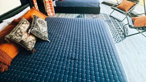 A tent-style room with two beds, patterned pillows, and a swing chair. - Customizable Multi-Dome Buyout (South Haven)