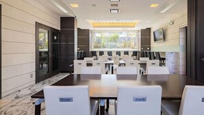 A conference room with a long table, white chairs, a large window, and a mounted TV. - Myhotel Okazaki (Okazaki)