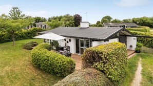 A modern house with a large patio, surrounded by well-maintained gardens and a clear sky. - Awesome home in Sydals with WiFi (Sydals)