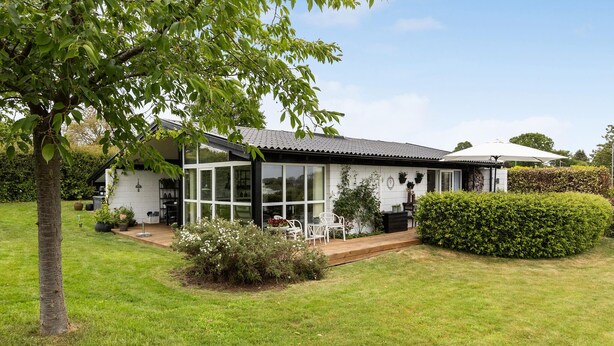 A modern house with a large glass window, a wooden deck, and a well-maintained garden. - Awesome home in Sydals with WiFi (Sydals)