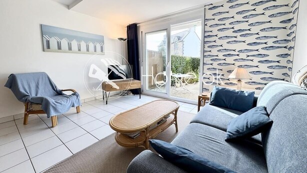 A modern living room with a sofa, armchair, and a small table.