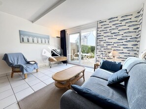 A modern living room with a sofa, armchair, and a small table.