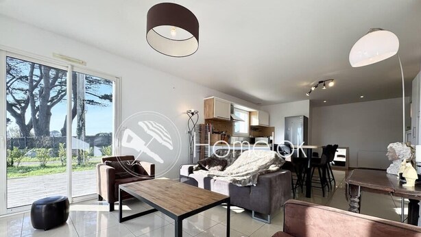 A modern living room with a sofa, coffee table, and a dining area with chairs.