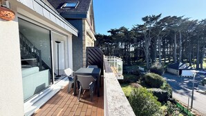 Una casa moderna con un patio, una puerta de cristal y un pequeño jardín.