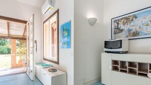 Una cocina moderna con microondas integrado, un lavamanos con lavabo azul y un cuadro enmarcado sobre la encimera.