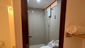 Une salle de bain avec des toilettes, une douche et un lavabo.