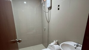 Une salle de bain moderne équipée de toilettes, d’un lavabo et d’une douche.