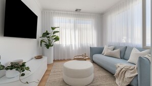 A modern living room with a light blue sofa, a round ottoman, and a large window with sheer curtains. - Horizons ~ Designer luxury stay with dream views (Aldinga Beach)