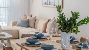 A dining area with a round table set for four, surrounded by wooden chairs. - Horizons ~ Designer luxury stay with dream views (Aldinga Beach)