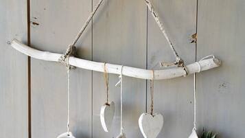 A rustic wall-mounted planter with three heart-shaped pots containing plants.
