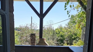 Une terrasse extérieure avec un banc en bois et une cheminée en pierre.