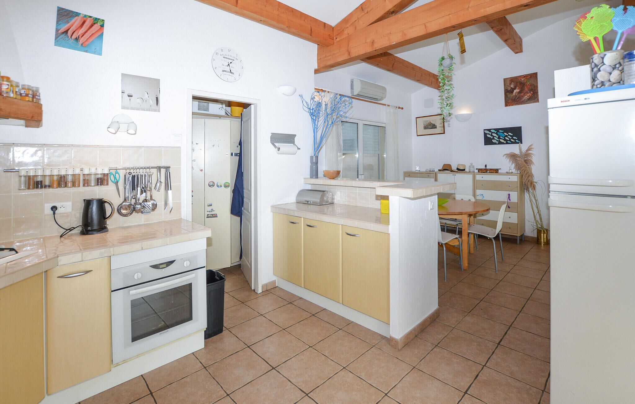 A compact kitchen with a stove, oven, and a small dining area with a table and chairs.