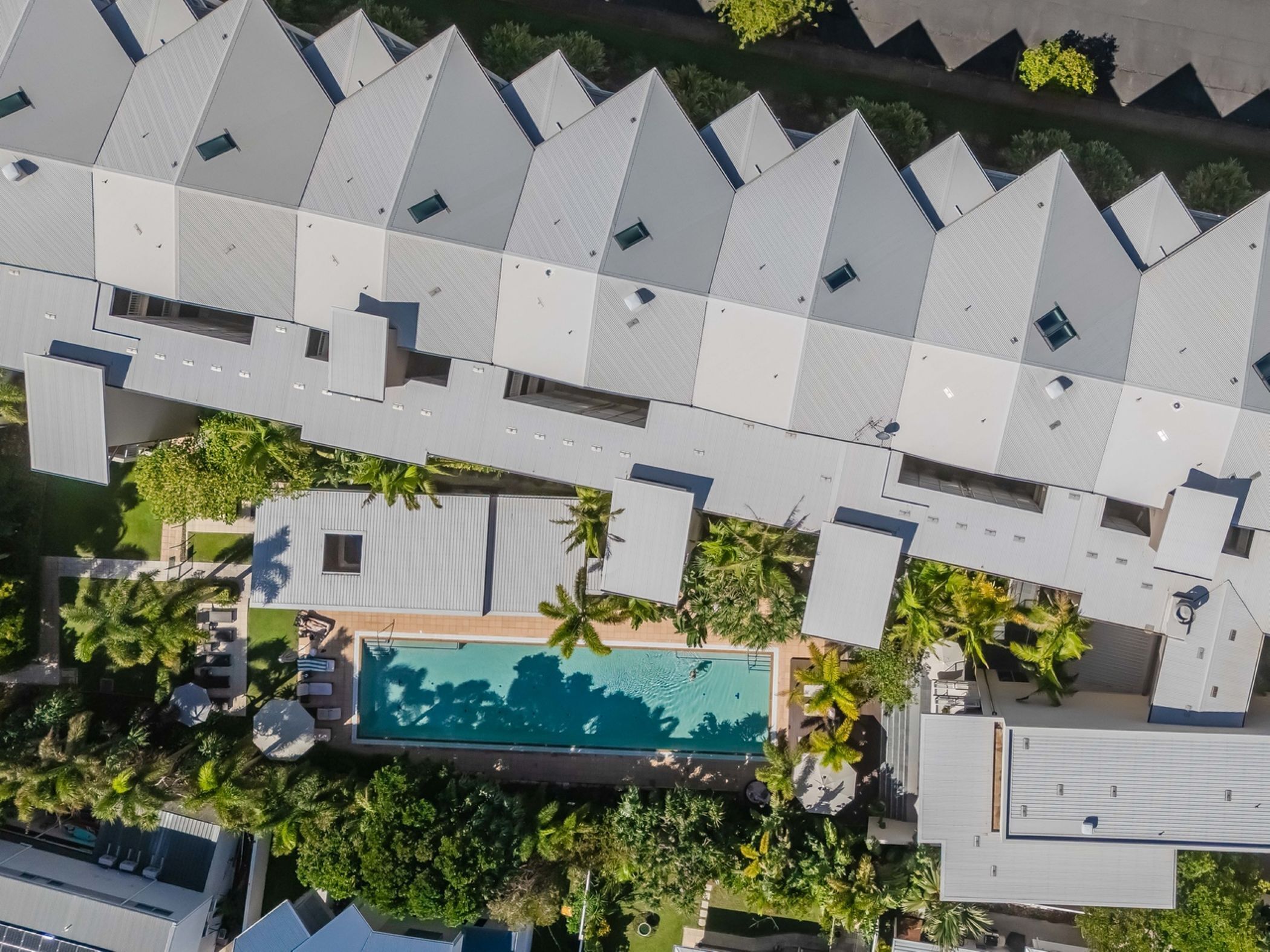 Vista aérea de un hotel con varias edificaciones, piscina y zonas verdes circundantes.