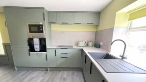 Una cucina moderna con elettrodomestici integrati, un lavello e una finestra.