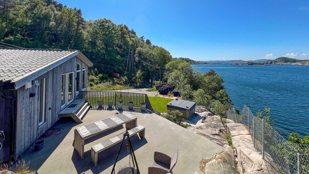 A wooden cabin with a patio, outdoor seating, and a view of the lake. - 2 bedroom amazing home in Mandal (Mandal)