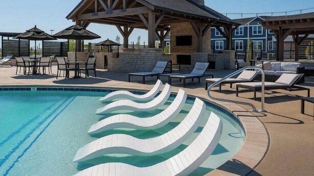 A swimming pool with wavy white steps, lounge chairs, and a covered seating area. - Earthy Elegance Spacious 2BR 2BA 2 KingBeds GymWFH (Whitestown)