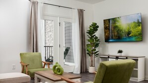 Ein modernes Wohnzimmer mit einer Couch, einem Esstisch und einem Blumentopf.