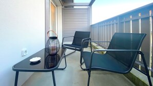 A balcony with a table, two chairs, and a lantern. - Remember - T2 near the ocean (Mimizan)