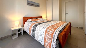 A bedroom with a bed, bedside tables, a lamp, a painting, and a door. - Remember - T2 near the ocean (Mimizan)
