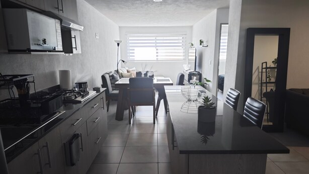 Eine moderne Küche mit Kochinsel, integrierten Geräten und einem Essbereich mit Sofa und Stühlen.