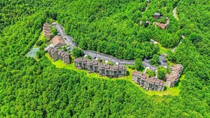 An aerial view of a residential area with multiple apartment buildings surrounded by dense greenery. - 🔥 Mountain Escape | Fireplace, Sky Deck & Year-Round Resort Perks! (Gatlinburg)