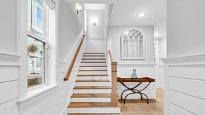 A staircase with wooden steps and a wooden handrail, leading to a landing with a table and a vase. - Golf Cart, Bikes, The Big Chill, Shuttle to Beach Seasonally, 2 Pools! (Alys Beach)