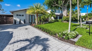 A modern house with a paved driveway, a well-maintained lawn, and a mailbox.