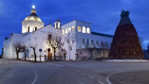 En kirke med en stor kuppel og et højt klokketårn, omgivet af et snedækket område.