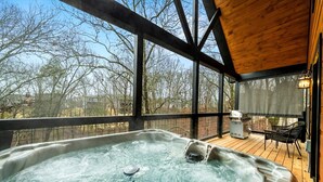 A hot tub on a wooden deck with a view of trees and houses. - New! Woodridge Lodge! 3 min to PF Pkwy! Pool,Pool Table,Hot Tub,Shuffboard,Poker (Pigeon Forge)
