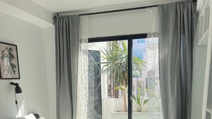 A bedroom with a bed, pillows, a lamp, and a view of the outside. - Stay in GAUTHIER studio M (Casablanca)