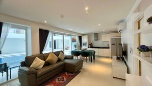 Una sala moderna con sofá, comedor y cocina.