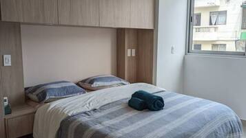2 habitaciones, escritorio y tabla de planchar con plancha