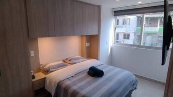 2 habitaciones, escritorio y tabla de planchar con plancha
