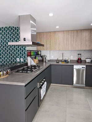 A modern kitchen with a gas stove, oven, and dishwasher.