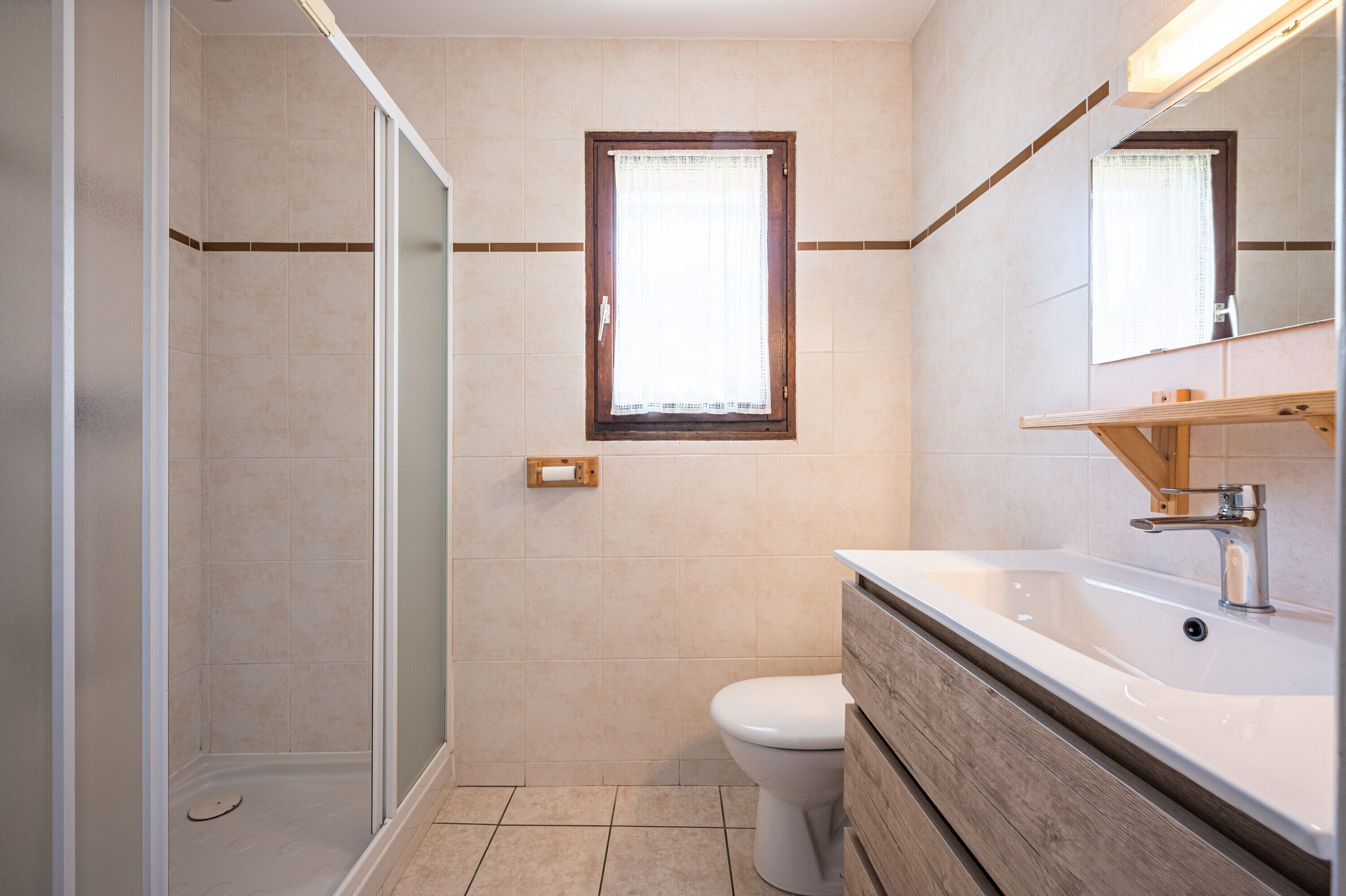 A bathroom with a shower, toilet, and sink.