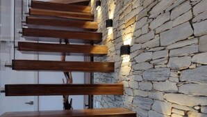 Una escalera de madera que sube a un muro de piedra.