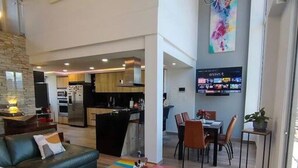 Una sala de estar moderna con un sofá modular, una mesa de centro y un televisor al fondo.
