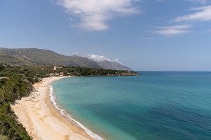 A coastal landscape with a beach, a mountain, and a tower. - Villa Loft 'Antico Baglio' – Scopello – Mountain View, Wi-Fi, Air Conditioning (Castellammare del Golfo)