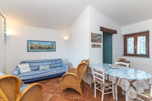Un coin repas comprenant une table, des chaises et un canapé à rayures bleues.