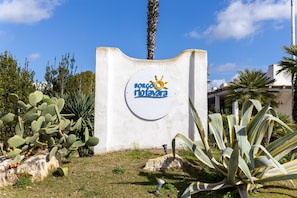 A sign with 'BORCO RIOJAVARA' and a sun symbol, surrounded by cacti and agave plants. - Apartment 'D R Holiday Home' with Private Garden close to the sea (Santa Maria del Focallo)