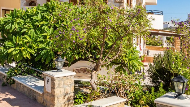 A two-story building with stone facade, wooden shutters, and a balcony with plants. - Apartment '1' with Mountain View, Wi-Fi and Air Conditioning (Karpathos Town)