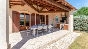 A covered patio with a table and chairs, a grill, and a stone pathway. - Holiday Home 'La Provençale' with Private Pool, Private Terrace and Wi-Fi (Châteaurenard)