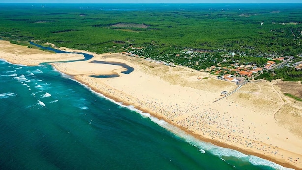 An aerial view of a beach with a winding river, a dense forest, and a small settlement with buildings. - Cozy Studio in Moliets et Maa with Private Terrace, Barbecue, Ideal for 4 Guests (Moliets et maa)