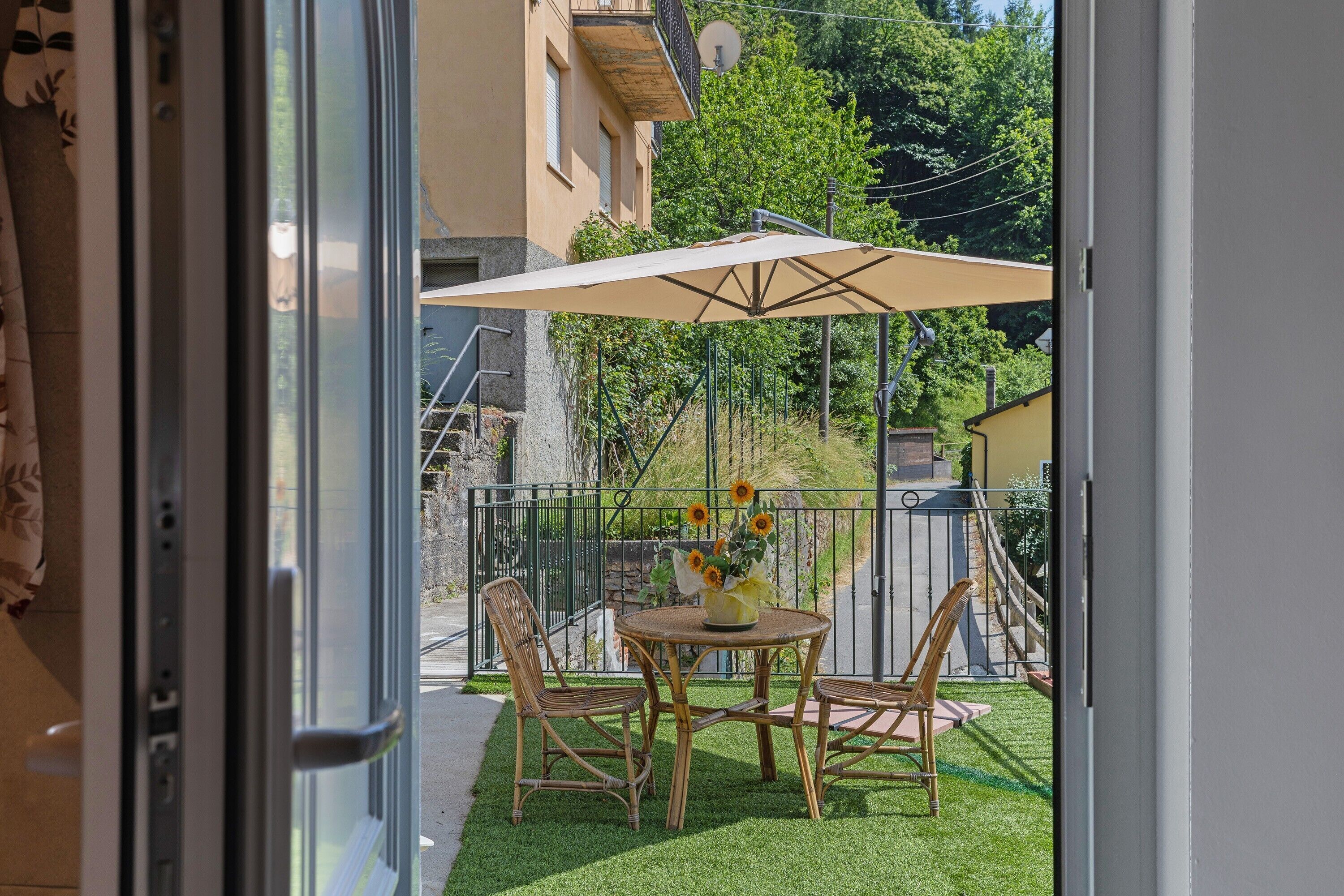 Un balcon avec une table, des chaises et un parasol.