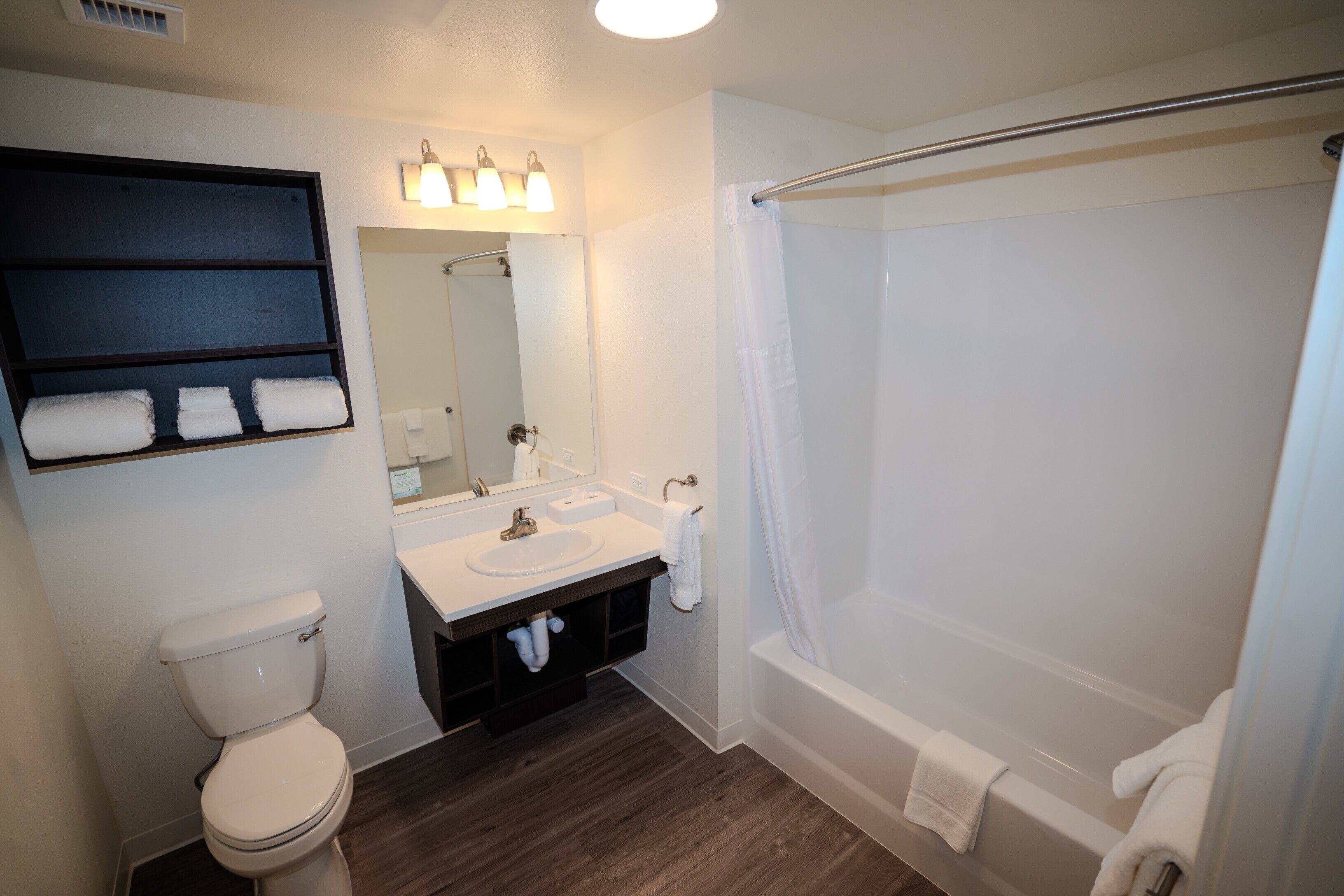 Ein Badezimmer mit Toilette, Waschbecken, Spiegel und Badewanne.